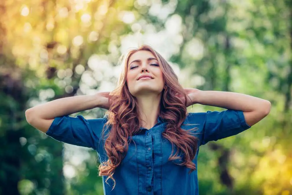 Woman in a blue shirt stretching her arms